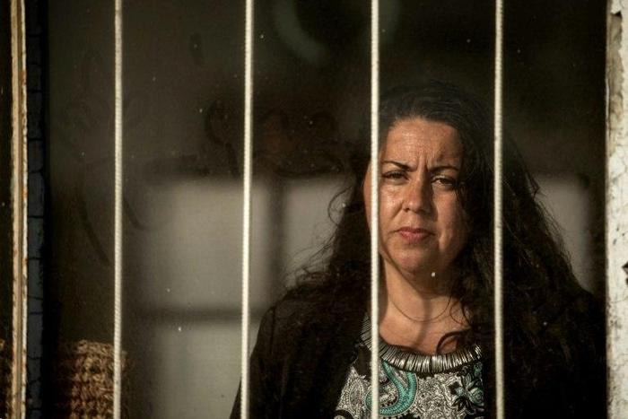 Jaqueline Jimenez looks out from the window of a building where she used to live, near Chile's port of Antofagasta