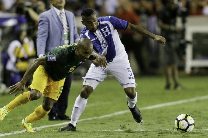 Florent Malouda (L) of French Guiana fights for the ball with Ever Alvarado of Honduras, at BBVA Compass Stadium in Houston, Texas, on July 11, 2017