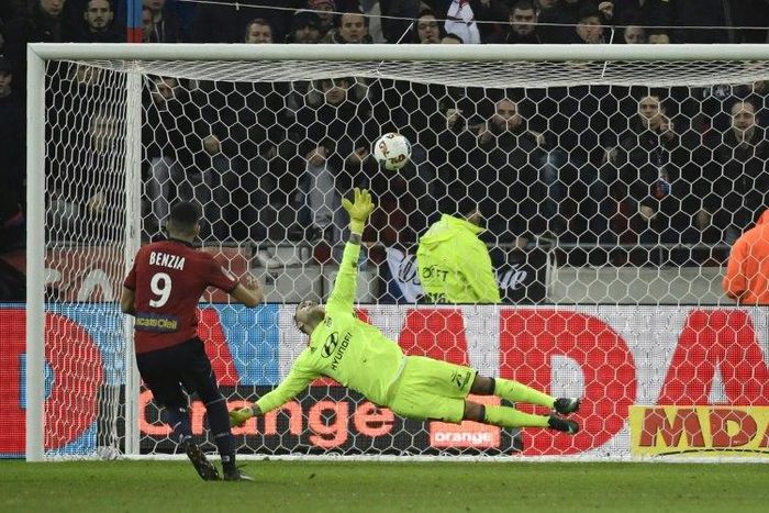 Lille's Yassine Benzia (L) kicks scores a penalty despite Lyon's Anthony Lopes (C) dive during their Ligue 1 match on January 28, 2017
