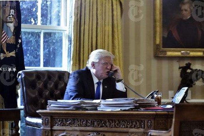 President Donald Trump speaks on the phone with Russia's President Vladimir Putin from the Oval Office of the White House on January 28, 2017, in Washington.