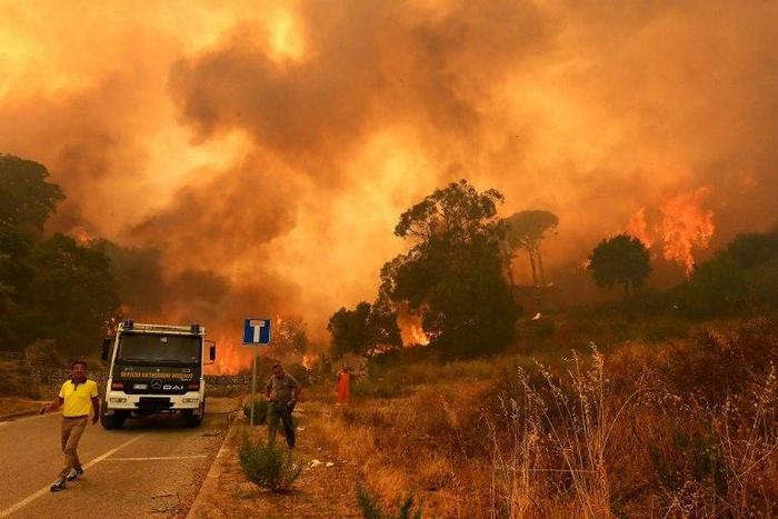 Firefighters get to work in the Annunziata district of Messina as a fire rages on July 10, 2017