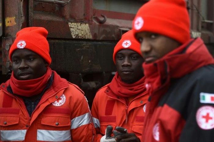 A group of migrants who volunteer with the Italian Red Cross stand at the Penna emergency operations center, 20 km from avalanche site that engulfed Hotel Rigopiano, in central Italy, on January 21, 2017