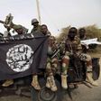 Nigerian soldiers hold up a Boko Haram flag that they had seized in the recently retaken town of Damasak, Nigeria, March 18, 2015. REUTERS/Emmanuel Braun