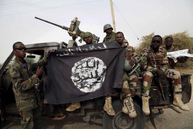 Nigerian soldiers hold up a Boko Haram flag that they had seized in the recently retaken town of Damasak, Nigeria, March 18, 2015. REUTERS/Emmanuel Braun