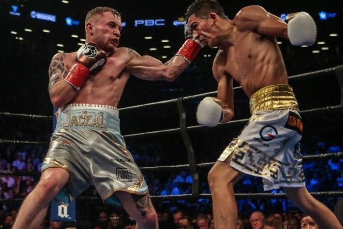 Leo Santa Cruz of Mexico (gold trunks) fights Carl Frampton of Northern Ireland (blue trunks) during their 12 round WBA Super featherweight championship bout at Barclays Center on July 30, 2016