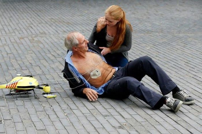 A woman gives a demonstration of an ambulance drone with built in defibrillator at the campus of the Delft Technical University in Delft on October 28, 2014. A Swedish report Tuesday said drones can drastically cut response times for delivering the lif...