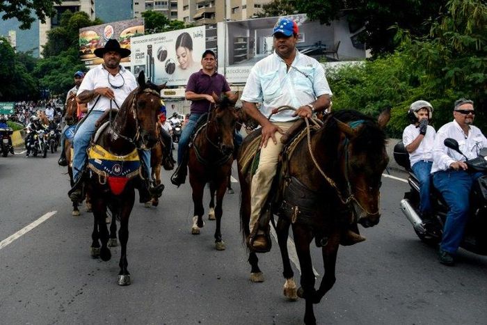 In the Venezuelan capital Caracas protesters on motorcycles, bikes and even horseback tried to clog a key highway clashing with riot police firing tear gas