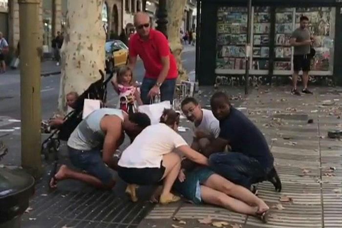 This video grab obtained from the instagram account carlos_tg_32_ shows people tending to an injured woman after a van ploughed into the crowd on Barcelona's popular Las Ramblas boulevard.