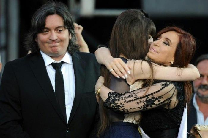 Argentina's then-President Cristina Kirchner (R) is embraced by her daughter Florencia next to her son Maximo, who went before a judge over their roles in the family's real estate company, during her inauguration ceremony in 2011