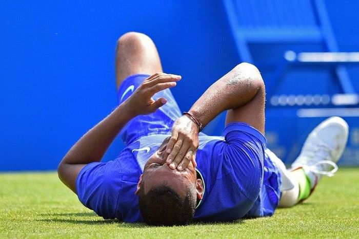 Australia's Nick Kyrgios reacts after slipping against Donald Young of the US in their men's singles first round match at Queen's Club in west London on June 19, 2017