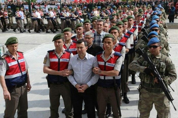 The suspects in the trial over the attempted coup in Turkey last year are paraded into the courtroom by heavily armed security forces