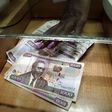 A teller serves a client with Kenya shilling notes at the cashier's booth of a forex exchange bureau in Kenya's capital Nairobi, April 20, 2016. REUTERS/Thomas Mukoya