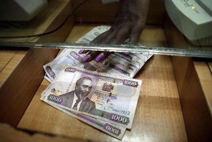 A teller serves a client with Kenya shilling notes at the cashier's booth of a forex exchange bureau in Kenya's capital Nairobi, April 20, 2016. REUTERS/Thomas Mukoya