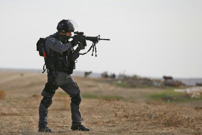 Israeli policeman takes aim in the Bedouin village of Umm al-Heiran, in the Negev desert, where police say they shot dead an Arab-Israeli in a car-ramming attack