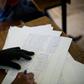 An election officials checks a list of voters names in Democratic Republic of Congo