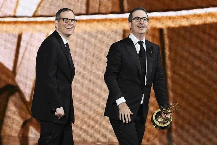 Writer/producer Tim Carvell (L) and TV personality John Oliver accept Outstanding Variety Talk Series for 'Last Week Tonight with John Oliver' at the 2016 Emmy Awards