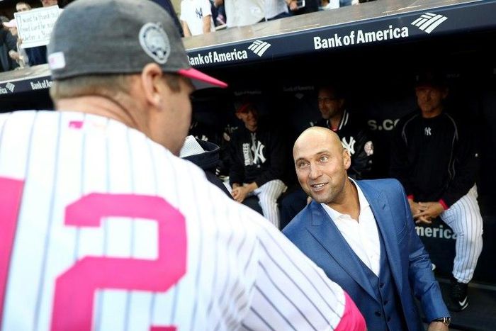 New York Yankees ex-captain Derek Jeter (R) greets former teammates at the ceremony to retire his No.2 jersey