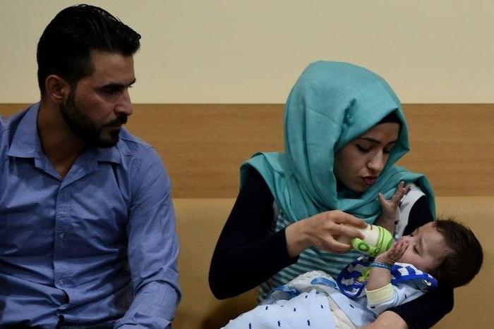 Parents Gufran Ali (C) and Sarwed Ahmed Nadar with their seven-month-old son Karam after his surgery in India to successfully remove his extra arms and legs