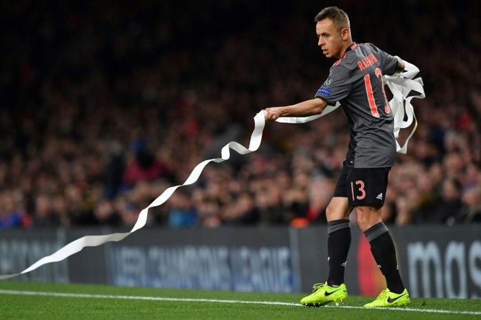 Bayern Munich's Brazilian defender Rafinha clears the pitch of toilet roll before the Champions League last 16 second-leg against Arsenal at The Emirates Stadium in London on March 7, 2017