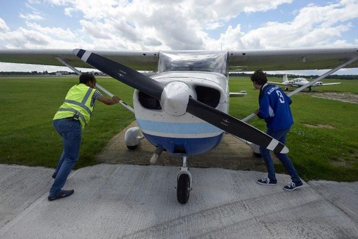 Pilot Somasekhara Pemmireddy (L) and passenger Adam Nicholas park the plane after a flight over the capital in a Cessna 172 plane, at the London North Weald airfield on August 1