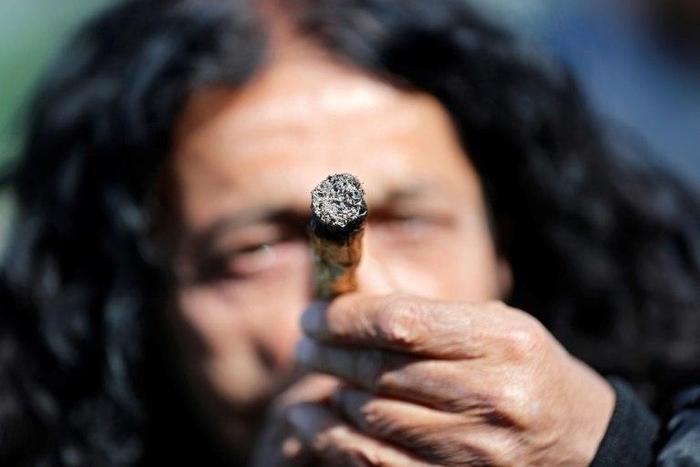 An Israeli smokes a marijuana joint in Jerusalem on April 20, 2017 during a rally to express their defiance of current laws