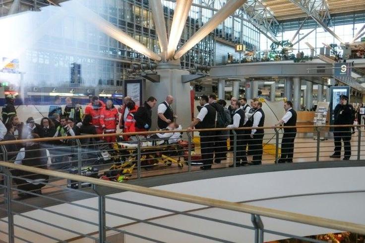 Firefighters take care of an individual on a stretcher inside Hamburg airport on February 12, 2017 in Hamburg, northern Germany, as emergency services evacuated the building after people reported respiratory ailments