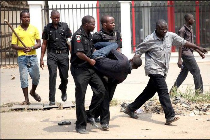 Policemen carrying a suspect (for Illustrative use)