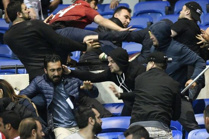Besiktas' and Lyon's supporters fight before their UEFA Europa League first leg quarter final football match on April 13, 2017, at the Parc Olympique Lyonnais stadium in Decines-Charpieu, central-eastern France