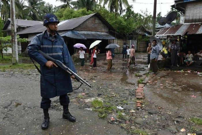An armed policeman stands guard during a visit of former UN secretary general Kofi Annan to the Aung Mingalar displacement camp for the minority Muslim Rohingya, in Sittwe, Myanmar in September 2016