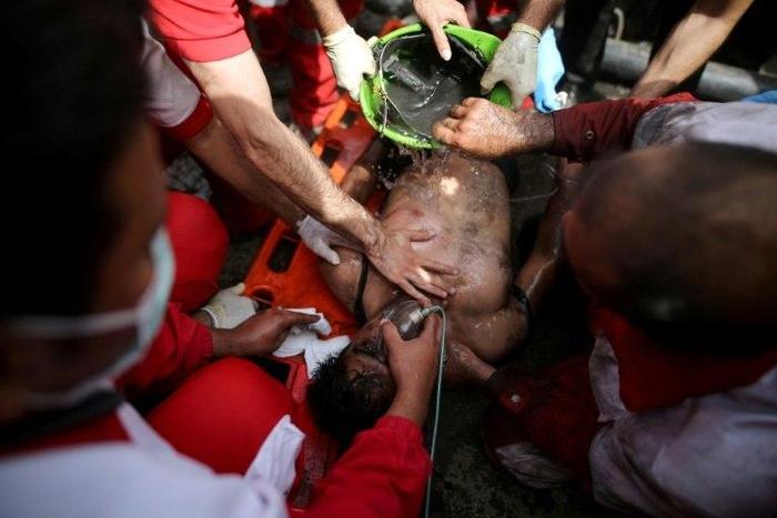 Rescue workers try to resuscitate a coal miner after he was pulled out from a mine in Azadshahr, northern Iran, following an explosion which left dozens of miners trapped on May 3, 2017