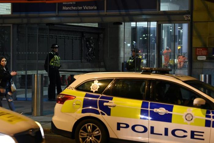 Police officers stand near a cordon at Manchester Victoria Station following a stabbing