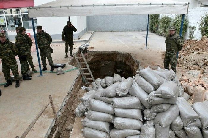 Military personnel of the Hellenic Army Explosive Ordnance Disposal (EOD) team stand at the site of a World War II bomb in Kordelio, a suburb of Thessaloniki, on February 12, 2017, ahead of an operation to defuse the bomb