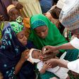 Nigerian health official administers a polio vaccine to a child in Kano, northern Nigeria