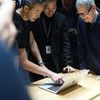 Apple plans to borrow for its new "advanced manufacturing" fund despite having money overseas, because of the tax it would pay if it brought profit home, said CEO Tim Cook (R)