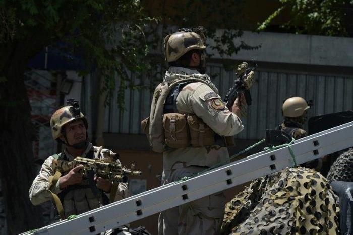 Afghan security forces stand guard at the site of a suicide blast near Iraq's embassy in Kabul