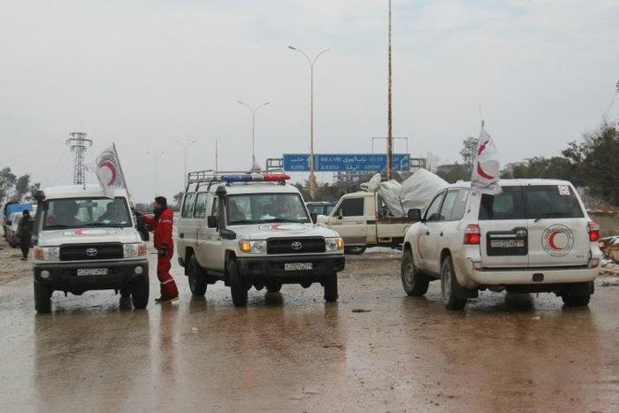 Staff of the Syrian Red Crescent wait on a road in December 2016 for evacuees from Fuaa and Kafraya, two Shiite-majority villages in northwestern Syria that are under siege by the Sunni Muslim rebels