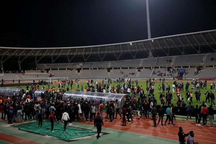 Supporters walk on the pitch after inviding it leading the referee to bring the friendly football match Ivory Coast vs Senegal to a premature end, on March 27, 2017, at the Charlety Stadium in Paris