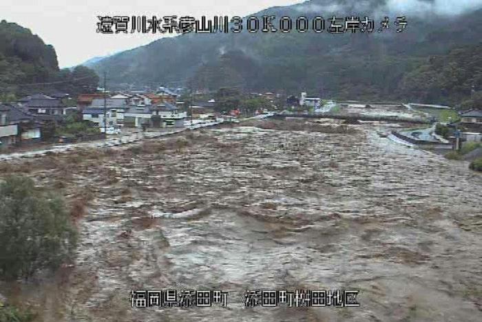 Roiling waters are sweeping through towns and villages in southwestern Japan, with at least 15 people reported missing