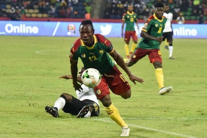 Cameroon's midfielder Christian Bassogog (C) advances past Ghana's midfielder Frank Acheampong to score his team's second goal during 2017 Africa Cup of Nations semi-final football match between Cameroon and Ghana in Franceville on February 2, 2017