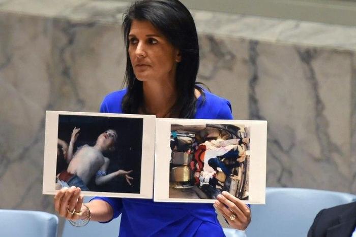 US Ambassador to the UN Nikki Haley holds photos of victims as the UN Security Council meets in an emergency session in April about a suspected deadly chemical attack that killed civilians, including children, in Syria