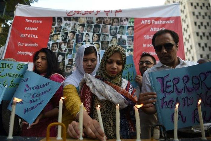 Residents of Karachi hold lighted candles during a ceremony on December 16, 2016, as they pay tribute to victims on the second anniversary of an attack on The Army Public School in the northwestern city of Peshawar Parents of children killed when Talib...