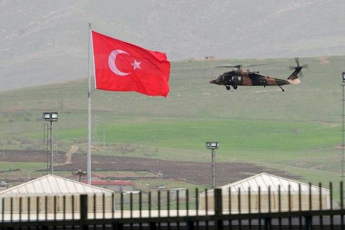 A helicopter files over the Habur border crossing, in Sirnak