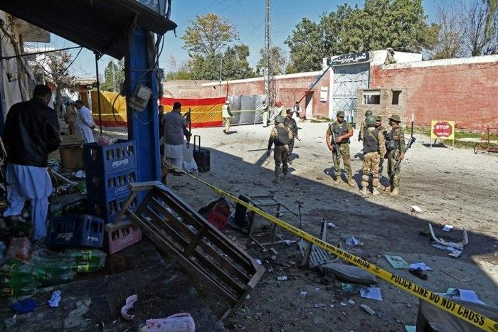 Pakistani soldiers stand guard at the site of a court complex in Tangi after multiple Taliban suicide bombings on February 21, 2017