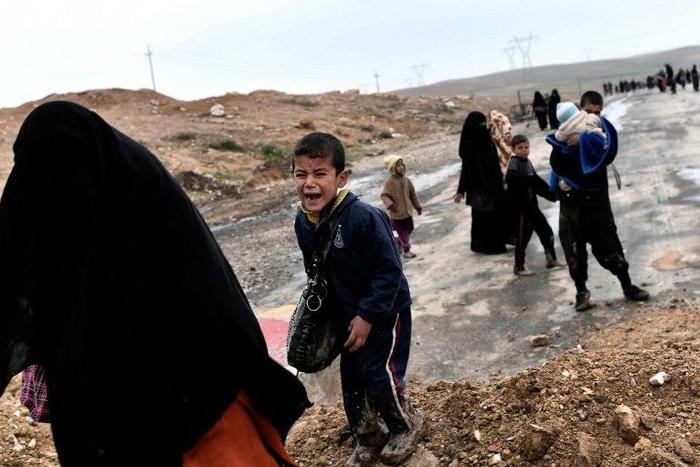 Iraqi civilians walk down a road as they flee the fighting in western Mosul, on March 3, 2017