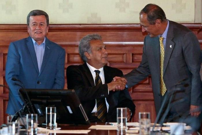 Colombia's government chief negotiator Juan Camilo Restrepo (R) shakes hands with Ecuador's President Lenin Moreno (C) as the National Liberation Army rebel group's chief negotiator, Pablo Beltran, looks on in Quito on August 28, 2017