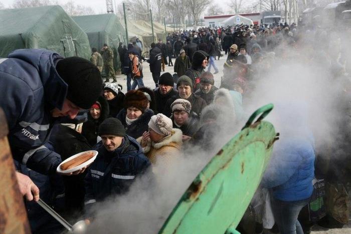 Rescue workers give food to residents in the Ukrainian town of Avdiivka on February 1, 2017 amid a spike in clashes between government forces and Russian-backed separatists