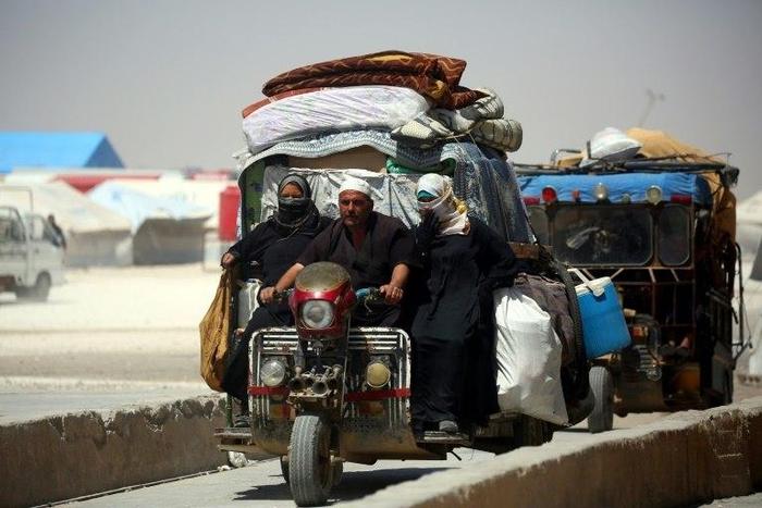 Displaced Syrians drive on June 10, 2017 at a temporary camp in the northern Syrian village of Ain Issa, where many people who fled the Islamic State group stronghold of Raqa are taking shelter