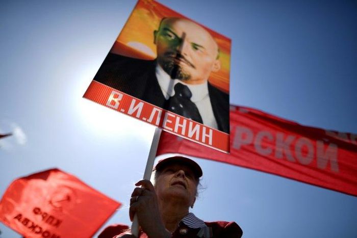 A Russian Communist party activist carries a banner with a portrait of late Soviet leader Vladimir Lenin during a May Day rally in central Moscow on May 1, 2017