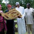 Buhari (centre) receives a giant Get Well card, in this handout photo taken on August 12 in London, where the Nigerian president has been receiving treatment for an undisclosed ailment for over three months