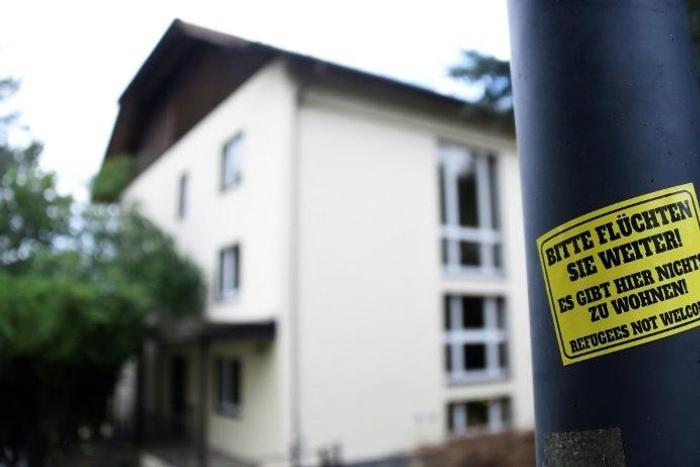 A sticker reading 'Please keep on fleeing - here is no place for you - refugees not welcome' is pinned at a lantern next to a refugee centre in Freital, eastern Germany